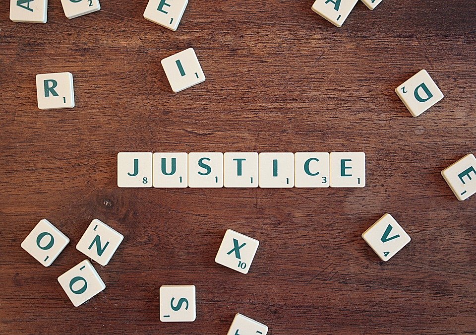 The word "justice" spelled in scrabble tiles