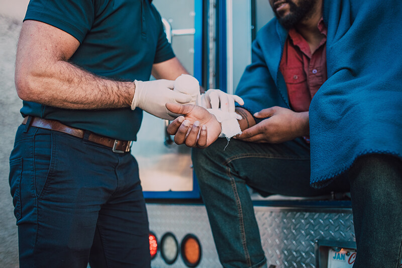 paramedic wrapping man’s wrist