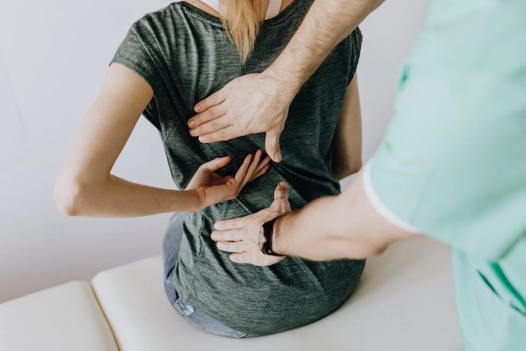 woman having back injury checked by physiotherapist