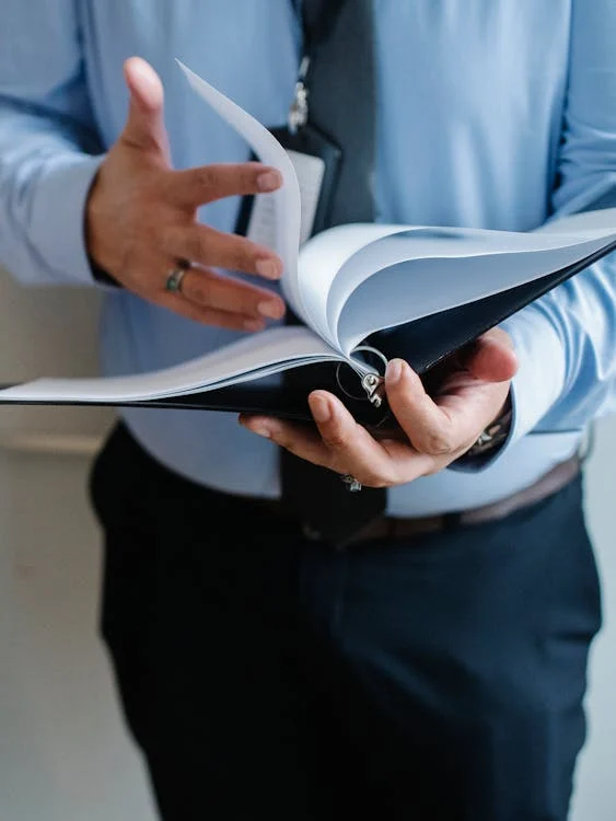 man in blue short flipping through binder