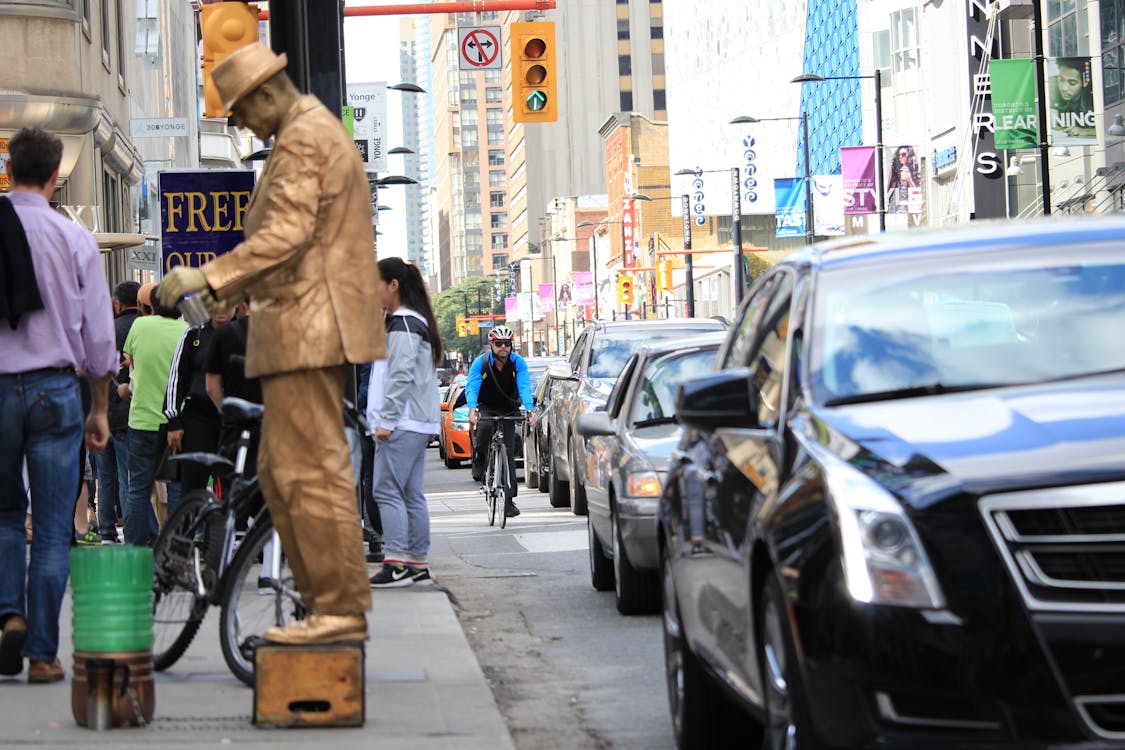 cyclist in between cars and pedestrians on busy street