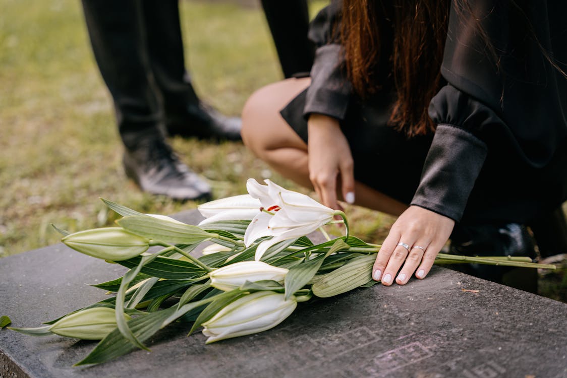 person laying flowers on grave