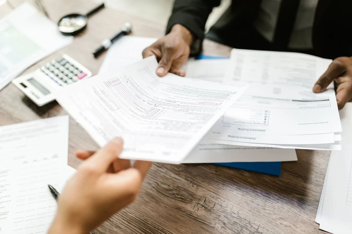 two people exchanging critical illness policy papers