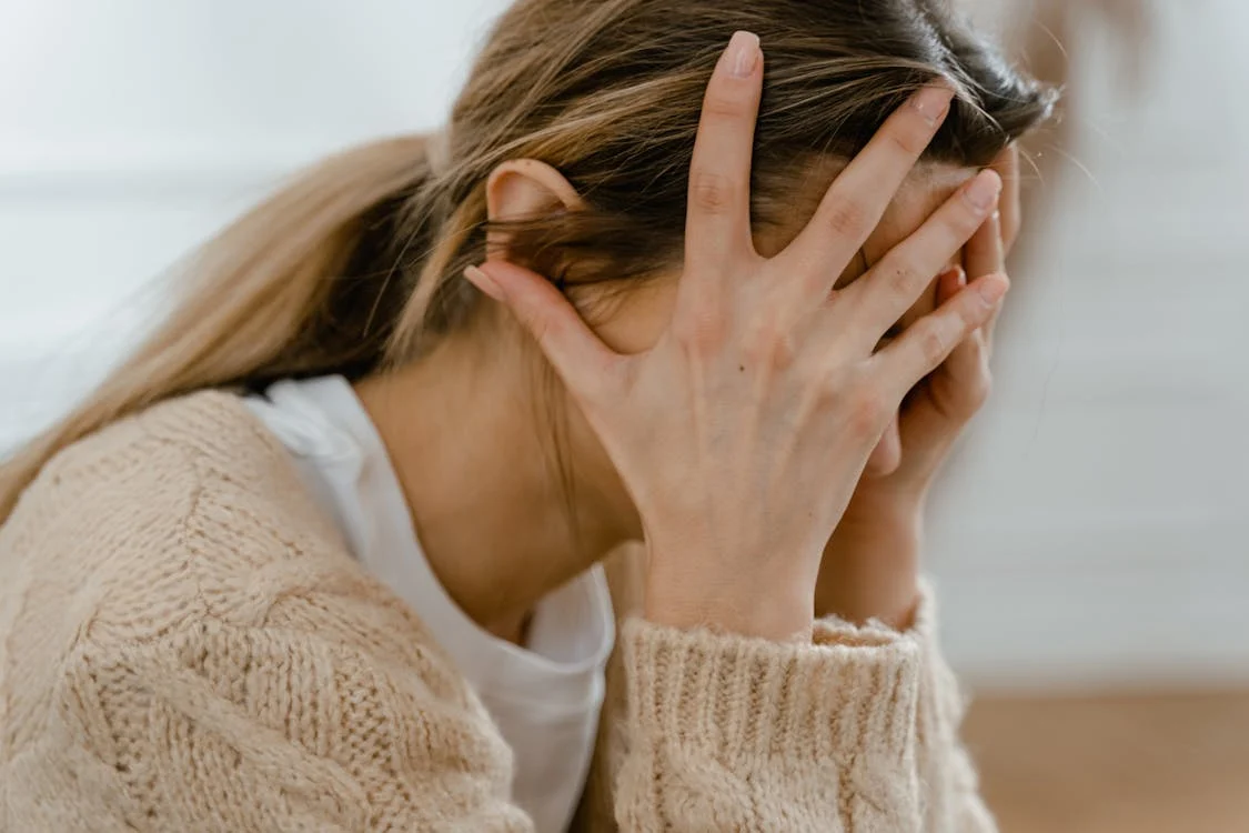 woman covering face with hands