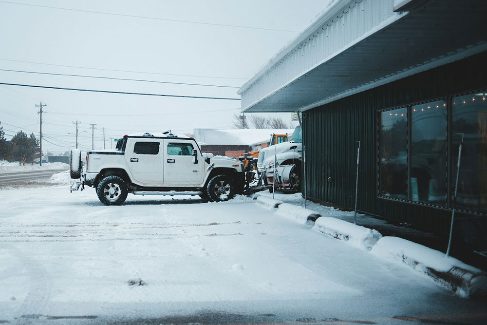 white pickup truck parked outside business on snow covered parking lot