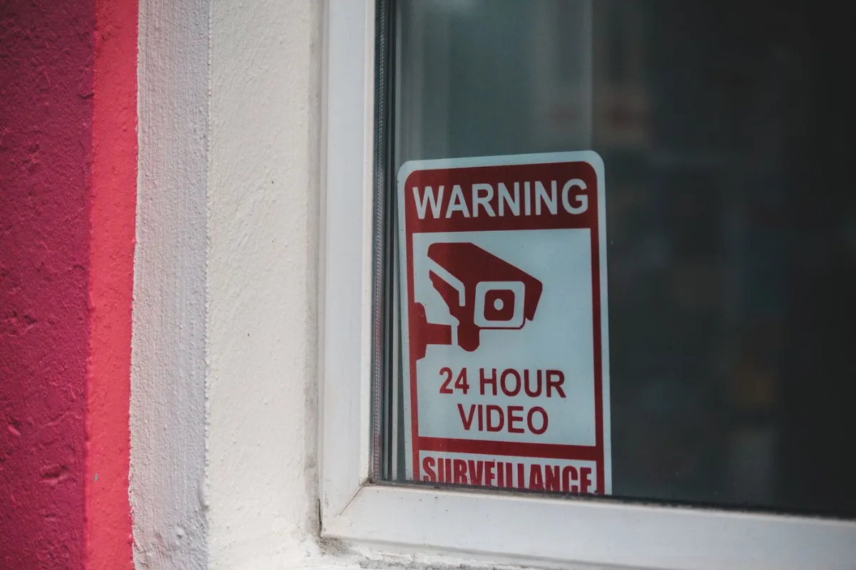 Close up of a sign that reads warning, 24 hour video surveillance displayed in a window Close up of a sign that reads warning, 24 hour video surveillance displayed in a window