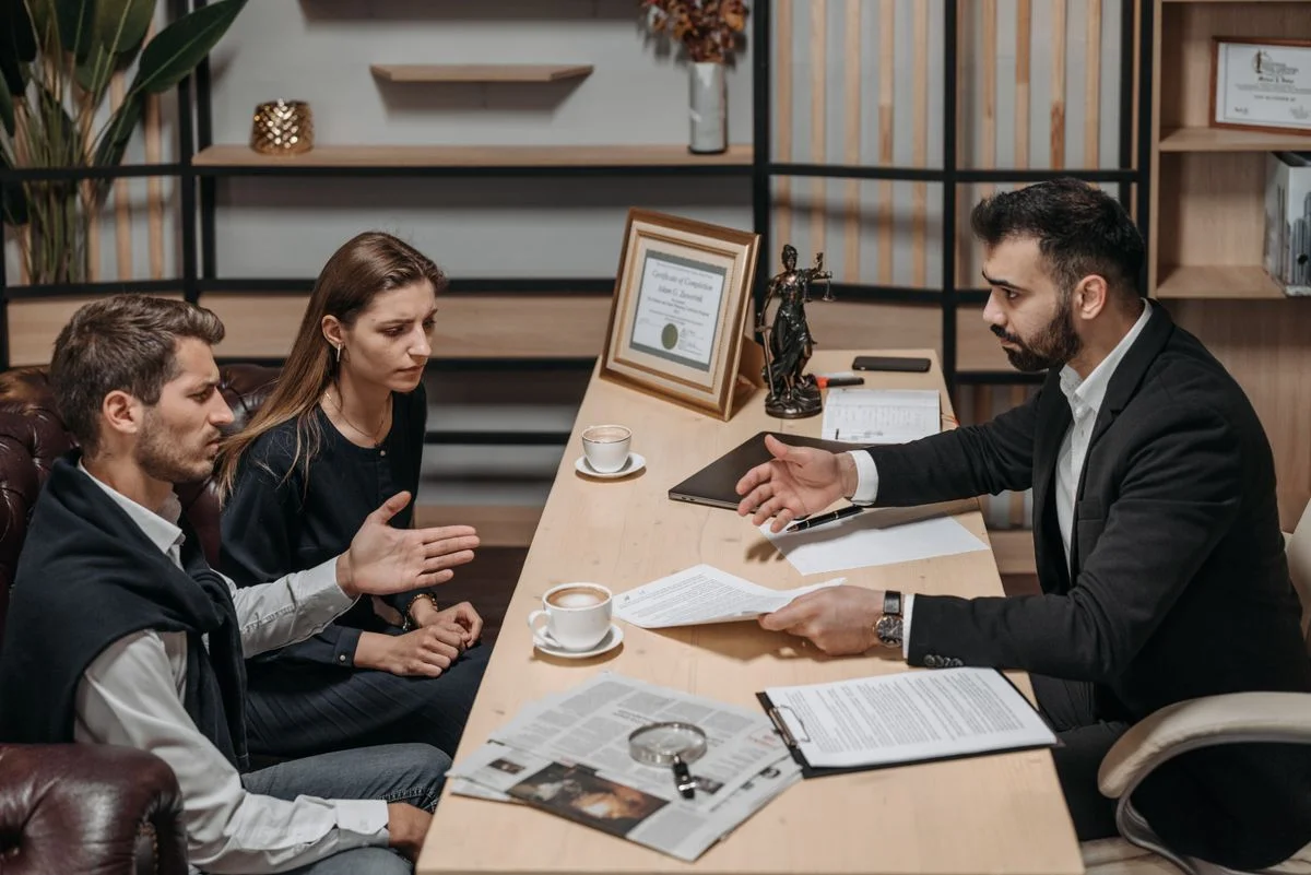 male-lawyer-talking-to-his-clients Photo of a male lawyer talking to his clients