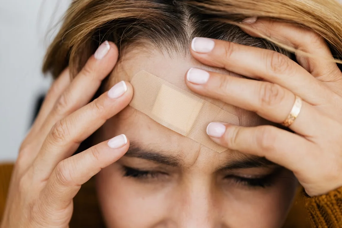 Close up of a female with a band-aid on her forehead